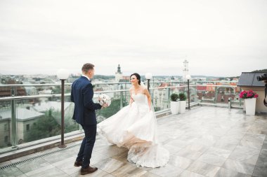 Yeni evliler için şık bir çift. Gelin, düğünlerinde damattan buketle parka koşuyor..