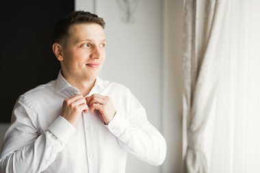 Güzel adam, damat poz veriyor ve düğüne hazırlanıyor..