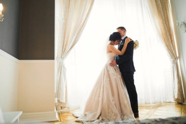 Romantik düğün anı, yeni evli çiftin gülümseyen portresi, gelin ve damadın kucaklaşması.