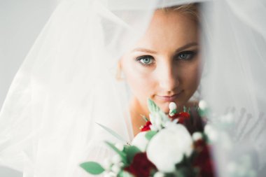 Beyaz elbiseli lüks gelin düğün törenine hazırlanırken poz veriyor..