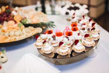 Lezzetli ve tatlı bir tatlı masası. Kapalı resepsiyonda küçük kekler ve shot 'lar var..