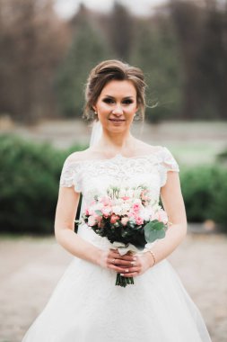 Gelin çiçekli büyük ve güzel bir düğün buketi tutuyor..