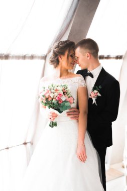 Güzel, genç bir çift ellerinde çiçeklerle poz veriyorlar..