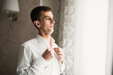 Güzel adam, damat poz veriyor ve düğüne hazırlanıyor..