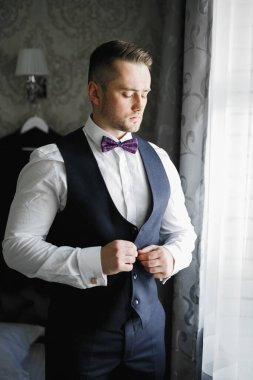 Damat sabah hazırlığı. Yakışıklı adam giyiniyor ve düğüne hazırlanıyor..