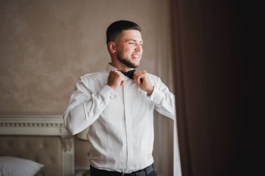 Güzel adam, damat poz veriyor ve düğüne hazırlanıyor..