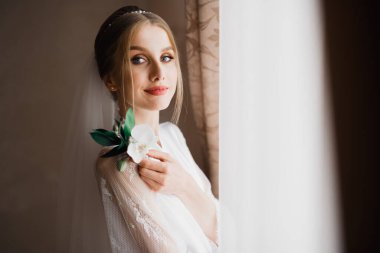 Lüks bir gelin, bir kız buketle poz veriyor ve gülümsüyor..