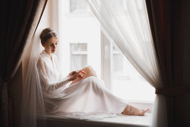 Beyaz elbiseli lüks gelin düğün törenine hazırlanırken poz veriyor..