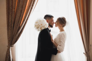 Göz kamaştırıcı mutlu çift birbirine yakın duruyor ve gözlerinin içine bakıyor..