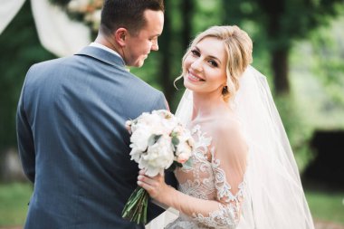 Güzel gelin ve damat evlendikleri gün kucaklaşıp öpüşüyorlar..