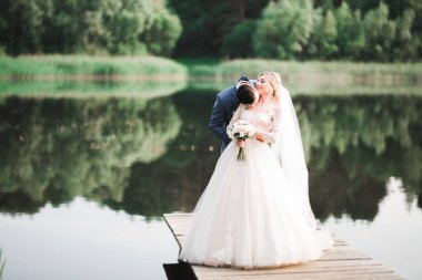 Güzel gelin ve damat evlendikleri gün kucaklaşıp öpüşüyorlar..