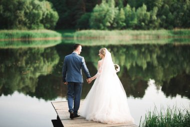 Güzel gelin ve damat evlendikleri gün kucaklaşıp öpüşüyorlar..