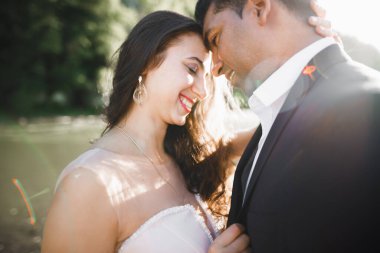 Romantik düğün anı, yeni evli çiftin gülümseyen portresi, gelin ve damadın kucaklaşması.