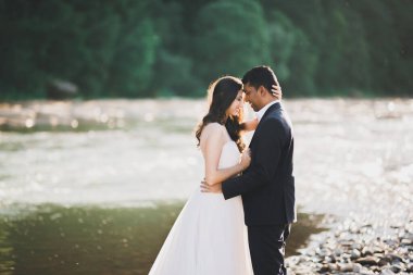 Romantik düğün anı, yeni evli çiftin gülümseyen portresi, gelin ve damadın kucaklaşması.