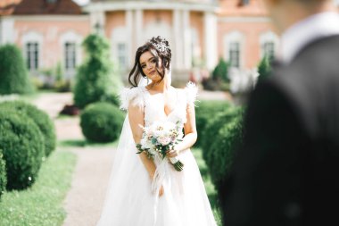 Gelin çiçekli büyük ve güzel bir düğün buketi tutuyor..