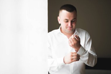 Güzel adam, damat poz veriyor ve düğüne hazırlanıyor..