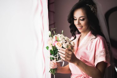 Gelin çiçekli büyük ve güzel bir düğün buketi tutuyor..