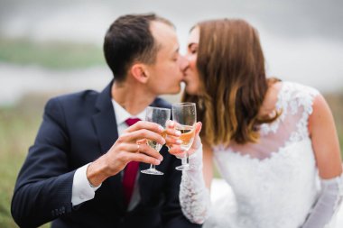 Gülen düğün çifti şampanya kadehleriyle şıngırdıyor..