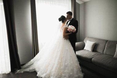 Güzel gelin ve damat düğün günlerinde kucaklaşıp öpüşürler..