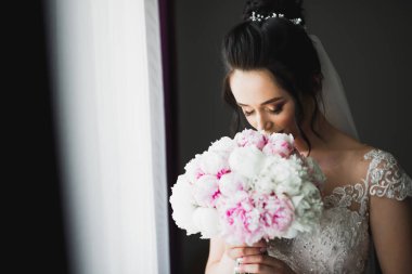 Gelin çiçekli büyük ve güzel bir düğün buketi tutuyor..