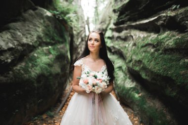 Gelin çiçekli büyük ve güzel bir düğün buketi tutuyor..