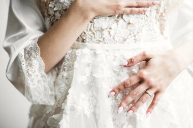 Cüppeli muhteşem gelin bir odada düğün töreni için poz veriyor ve hazırlanıyor..