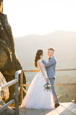 Göz kamaştırıcı mutlu çift birbirine yakın duruyor ve gözlerinin içine bakıyor..