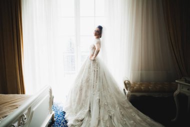 Beyaz elbiseli lüks gelin düğün törenine hazırlanırken poz veriyor..