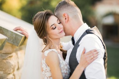 Romantik düğün anı, yeni evli çiftin gülümseyen portresi, gelin ve damadın kucaklaşması.