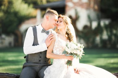 Doğadaki düğün çifti birbirine sarılıyor. Beyaz elbiseli güzel bir kız. Takım elbiseli adam.