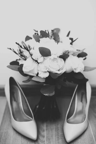 一双典雅时髦的新娘鞋和一束玫瑰和其他花朵 — 图库照片