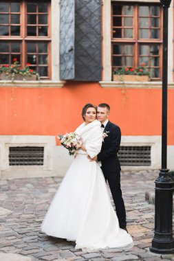 Romantik düğün anı, yeni evli çiftin gülümseyen portresi, gelin ve damadın kucaklaşması.