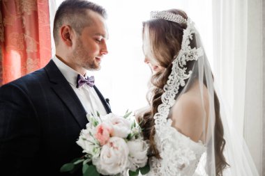 Göz kamaştırıcı mutlu çift birbirine yakın duruyor ve gözlerinin içine bakıyor..