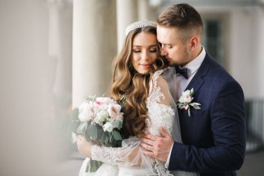 Romantik düğün anı, yeni evli çiftin gülümseyen portresi, gelin ve damadın kucaklaşması.