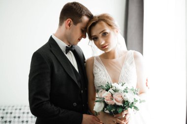 Romantik düğün anı, yeni evli çiftin gülümseyen portresi, gelin ve damadın kucaklaşması.