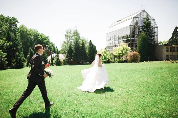부부들 결혼식 꽃다발을 공원에서 과뛰는 — 스톡 사진