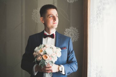 Güzel adam, damat poz veriyor ve düğüne hazırlanıyor..