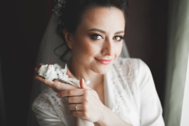 Beyaz elbiseli lüks gelin düğün törenine hazırlanırken poz veriyor..