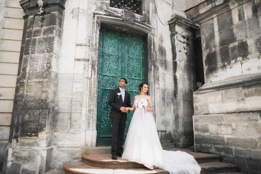 Doğadaki düğün çifti birbirine sarılıyor. Beyaz elbiseli güzel bir kız. Takım elbiseli adam.