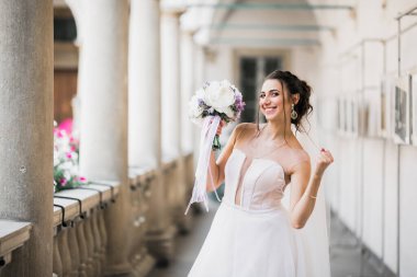 Gelin çiçekli büyük ve güzel bir düğün buketi tutuyor..