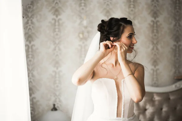 豪華な喜びのメイクアップと髪型と羽でファッションウェディングドレスを身に着けている美しい花嫁 スタジオ屋内写真撮影 — ストック写真