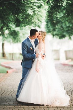 Güzel, genç bir çift ellerinde çiçeklerle poz veriyorlar..