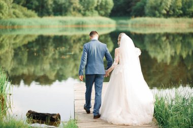 Güzel, genç bir çift ellerinde çiçeklerle poz veriyorlar..