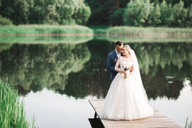 Güzel, genç bir çift ellerinde çiçeklerle poz veriyorlar..