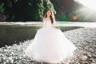 Nehrin kenarında duran uzun saçlı güzel gelinin portresi..