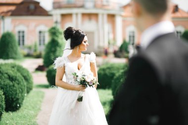 Çekici gelinin portresi, uzun saçlı, büyük buketli poz veren..