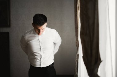 Damat sabah hazırlığı. Yakışıklı adam giyiniyor ve düğüne hazırlanıyor..