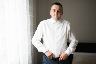 Güzel adam, damat poz veriyor ve düğüne hazırlanıyor..