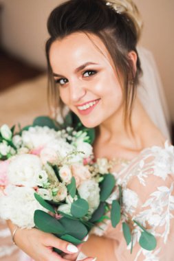 Gelin çiçekli büyük ve güzel bir düğün buketi tutuyor..