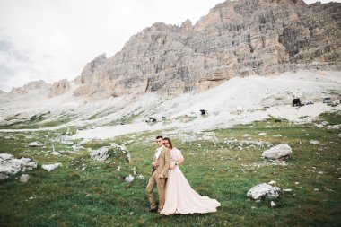 Dağlarda güzel genç bir çift. Aşıkların kış yürüyüşü. Erkek kadına sarılıyor..